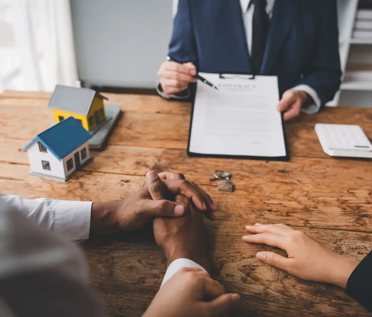 Couple signing home purchase agreement with agent