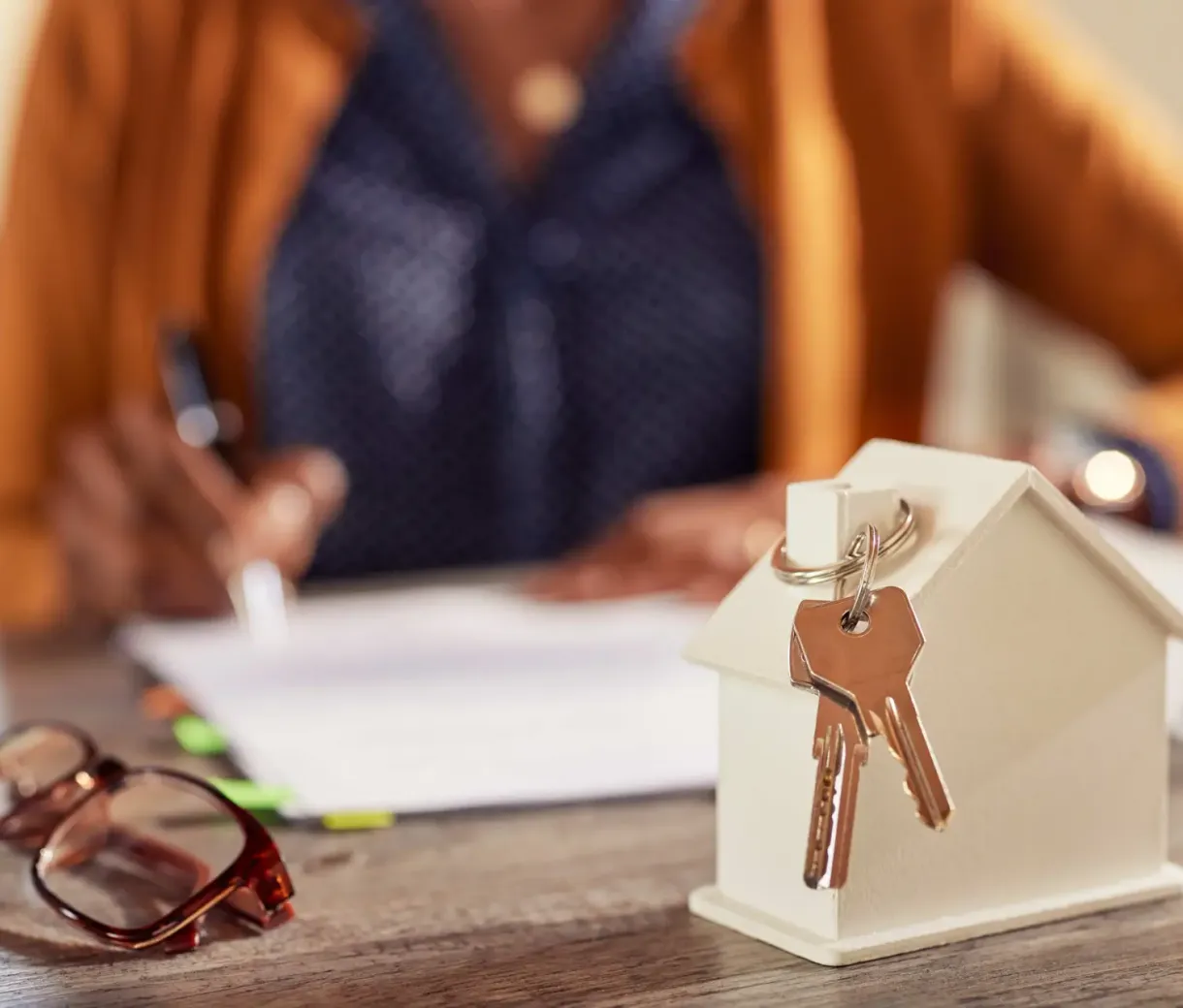 House model with keys and paperwork signing
